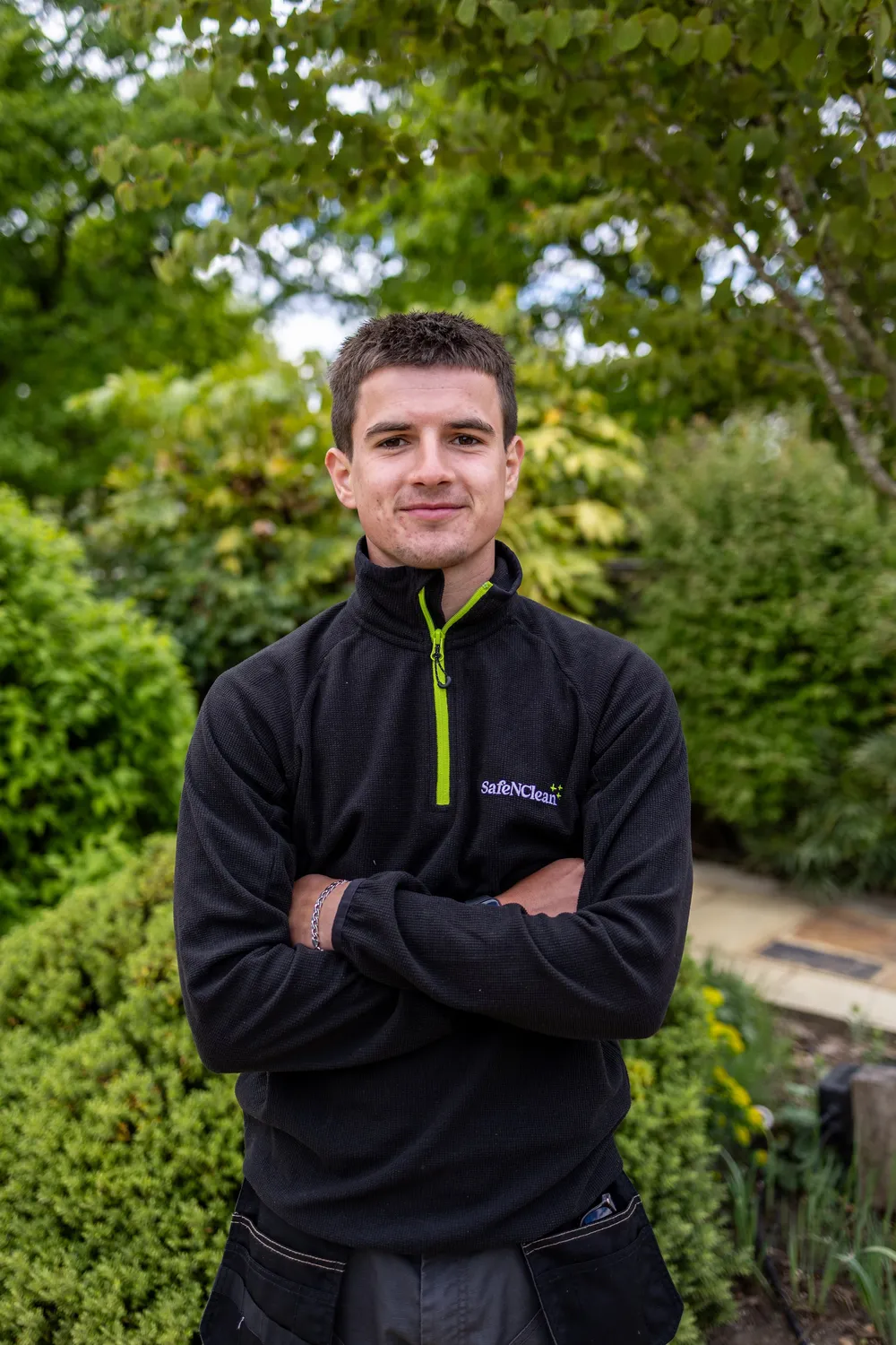 Member of the Safe'N'Clean team in branded workwear outside a house